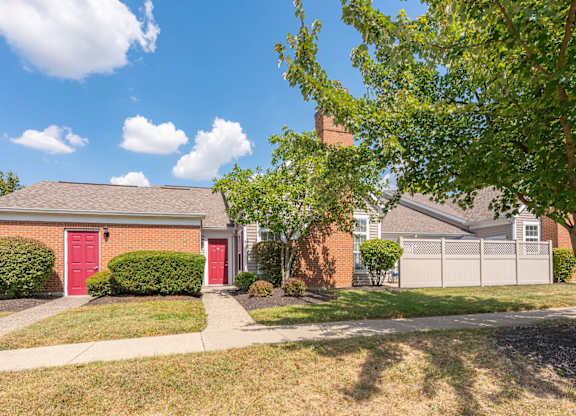 A red garage door is on the left side of a house.
