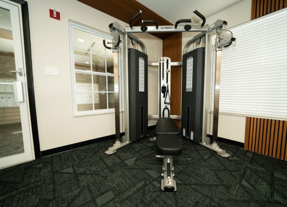 Gym with weights and a chair in the corner of a room at Honey Creek, Greenwood
