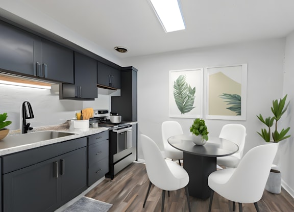 a kitchen with black cabinets and a table and chairs