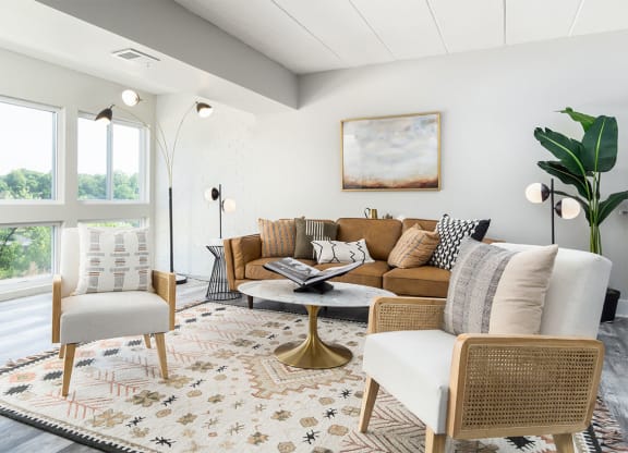 an image of a living room with chairs and tables and a clock at The Heights Apartments, Cincinnati, OH