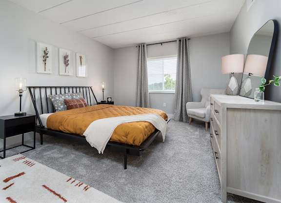 a bedroom with a bed and a dresser at The Heights Apartments, Ohio