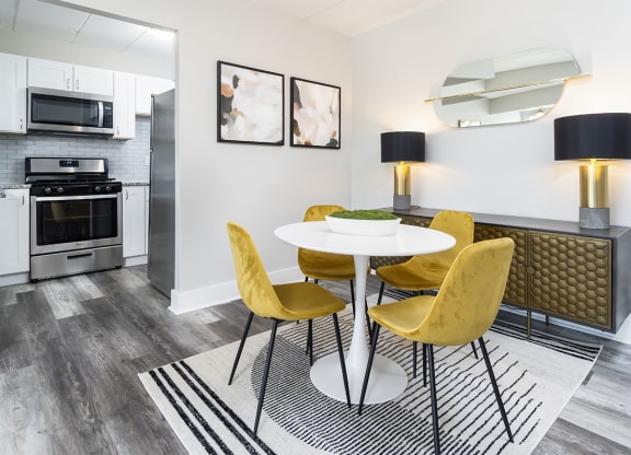 a dining room with yellow chairs and white tables at The Heights Apartments, Cincinnati, OH, 45220