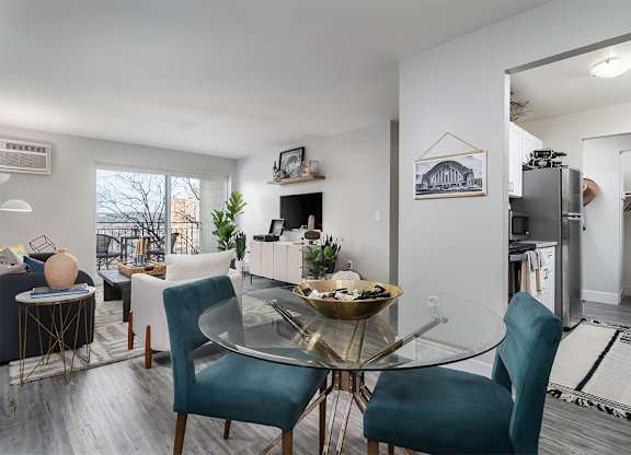an open living room and dining room with a glass table at The Heights Apartments, Cincinnati, Ohio