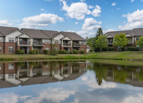 an apartment complex with a pond in front of it at Four Bridges, Liberty Township, 45044-8380