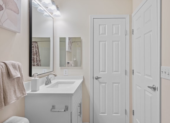 Bathroom with a white sink and a white door at Four Bridges, Liberty Township