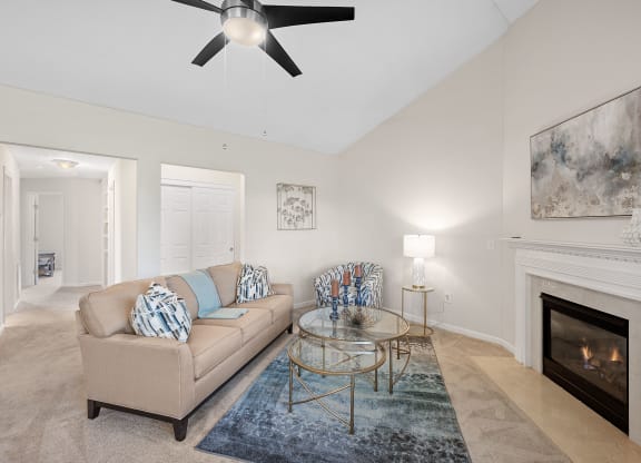 Living room with a couch and a glass coffee table and a fireplace at Four Bridges, Liberty Township, OH, 45044-8380