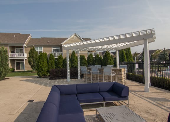 a patio with a couch and a table under a white pergola  at Grove City Summit, Ohio