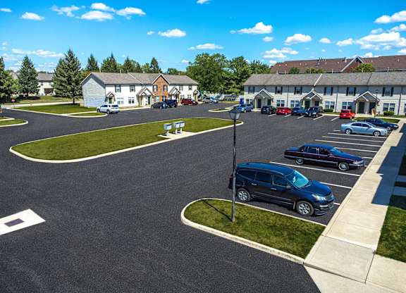 A parking lot with cars and a building in the background.