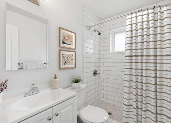 A white bathroom with a shower curtain and a toilet.