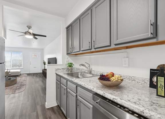 A kitchen with a marble countertop and a bowl of fruit on it.