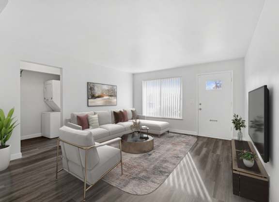 A living room with a white couch, a coffee table, and a television.