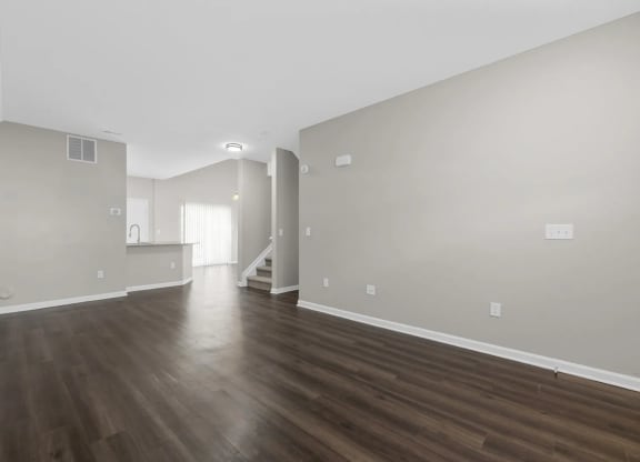 the living room and dining room of an empty house with wood floors at Traditions at Slate Ridge, Reynoldsburg, 43068
