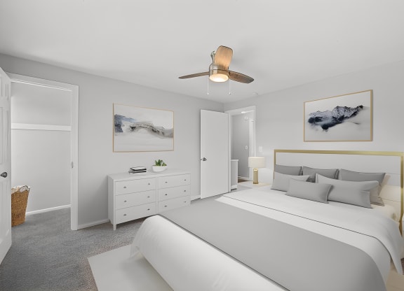 a white bedroom with a large bed and a ceiling fan at Huntley Ridge, Kettering
