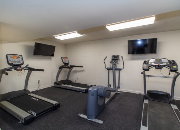 two exercise machines and a tv in a gym room at Rivers Edge Apartments and Townhomes, Dayton, OH, 45405