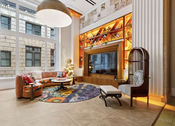 A living room with a couch, chair, and rug.