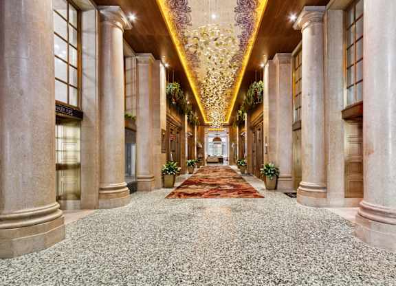 A long hallway with a carpeted floor and columns on either side.