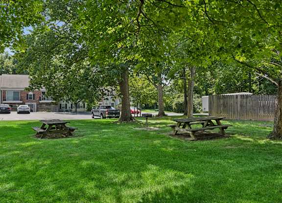 A park with picnic tables and a fence.