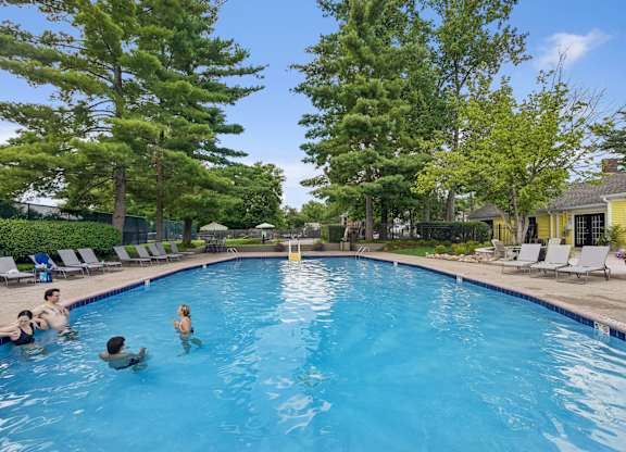 A group of people are swimming in a blue pool.