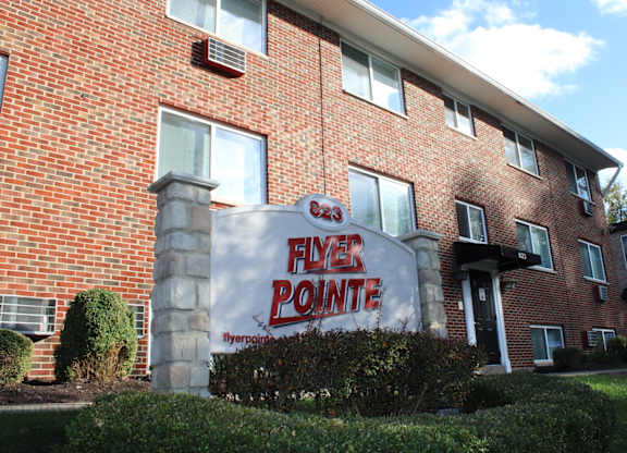 A brick building with a sign that says Flyer Pointe.