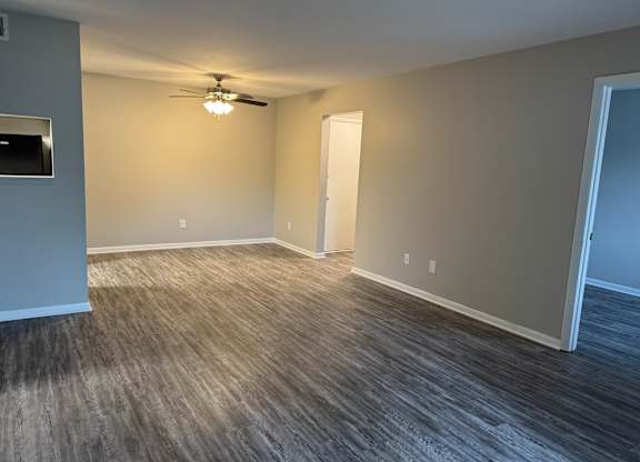 A room with a ceiling fan and a door. at Quail Run Apartments, Columbus
