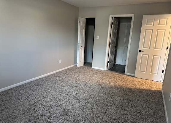 A room with grey carpet at Quail Run Apartments, Columbus, IN