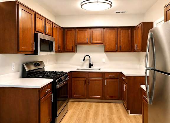 A kitchen with wooden cabinets and a stainless steel refrigerator at Indian Mound, Columbus, OH 43207