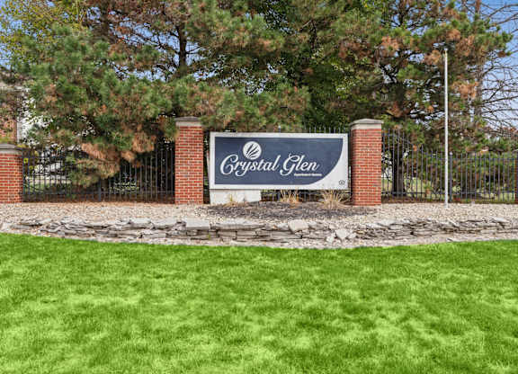 A sign that says Crystal Glen stands in front of a gate.