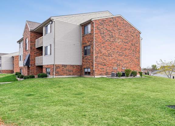 A red brick building with a green lawn in front.