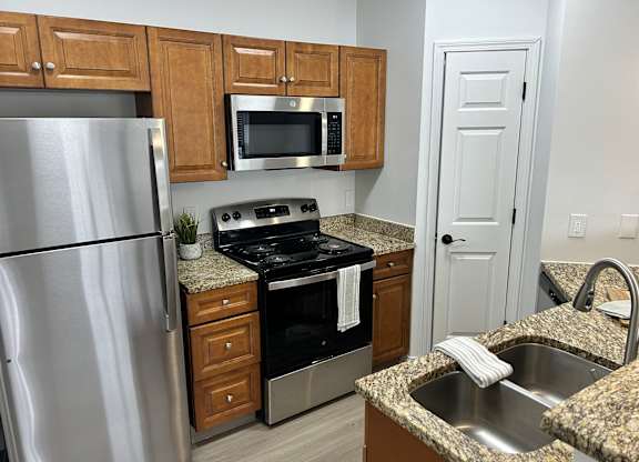A kitchen with a granite countertop and stainless steel appliances.