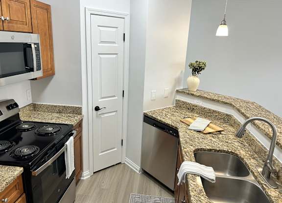 A kitchen with granite countertops and stainless steel appliances.