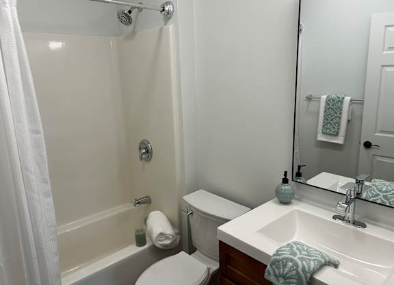 A white toilet sits next to a white sink in a bathroom.