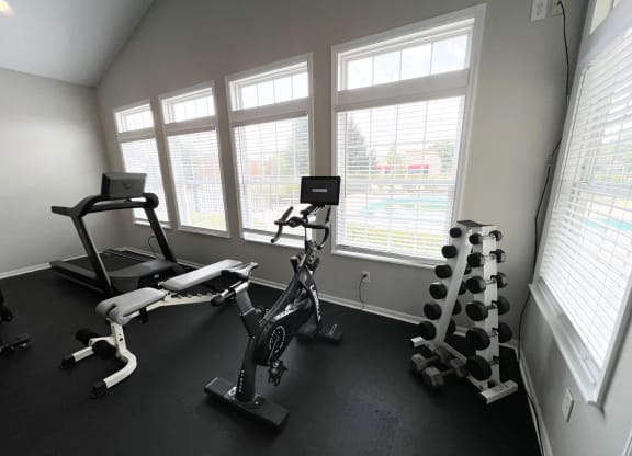 a gym with exercise equipment in a room with windows at Traditions at Slate Ridge, Reynoldsburg Ohio