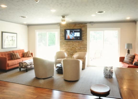 a living room with couches and chairs and a television at Quail Run Apartments, Indiana