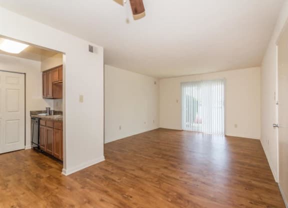 an empty living room and kitchen with a wood floor at Quail Run Apartments, Columbus