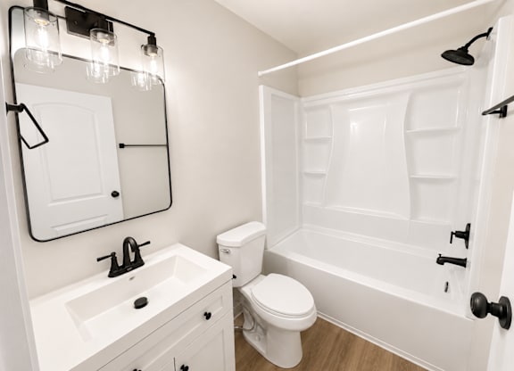 A white bathroom with a toilet, sink, and bathtub.