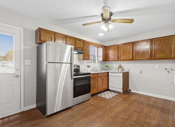 A kitchen with wooden cabinets and a stainless steel refrigerator.