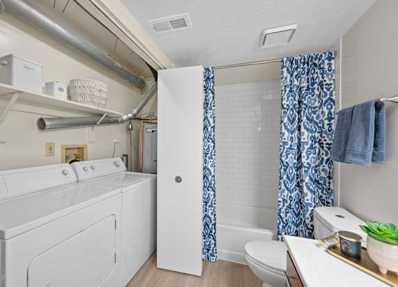 A white washing machine and dryer in a small laundry room.