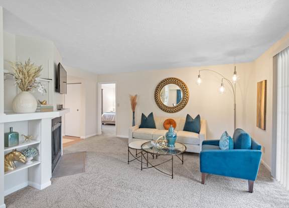 A living room with a blue couch and a fireplace.