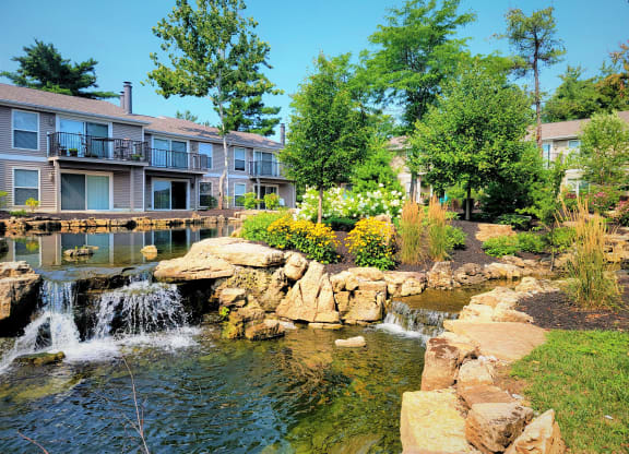 a pond with a waterfall in front of a building at Harpers Point Apartments, Cincinnati, OH, 45249