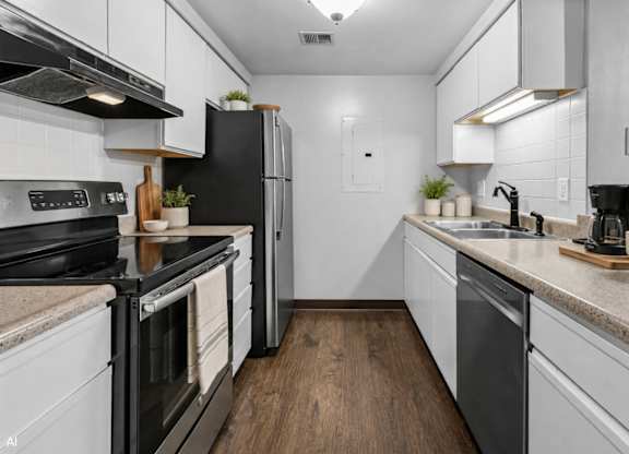 A modern kitchen with black appliances and white cabinets.