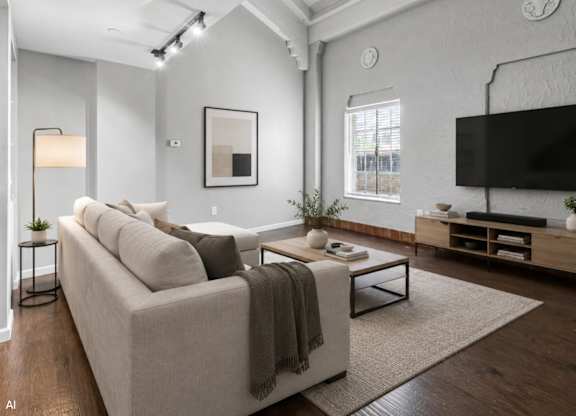 A modern living room with a grey couch, a coffee table, and a flat-screen TV.