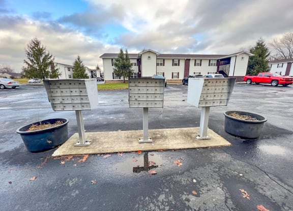 a parking lot with four parking meters in front of a building at Ridgeview, Indiana