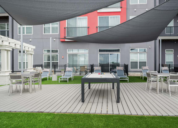 West Chester OH pet Friendly Apartments - Liberty Center - Outdoor Recreation Area with Pool Table, Lounge Chairs, Tables, Egg Chairs, Turf, Fire Pit, and Canopy Cover