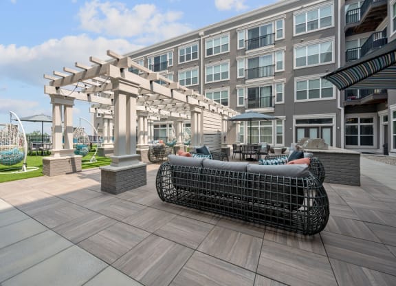 a patio with furniture and a building in the background
