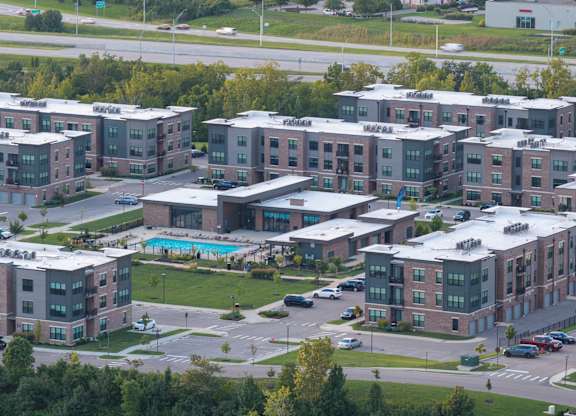 A large complex of red brick buildings with a pool in the middle.