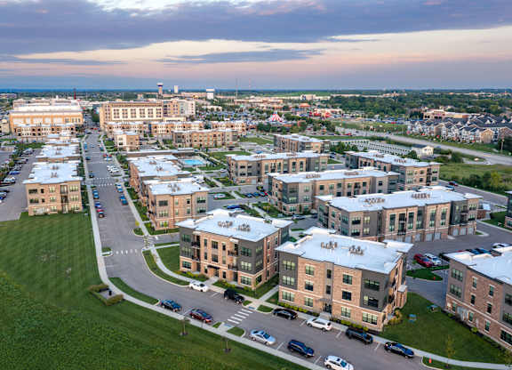 A large building complex with a parking lot in front.