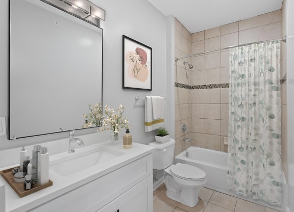 a white bathroom with a shower toilet and sink at Monmouth Row Apartments, Newport, KY, 41071
