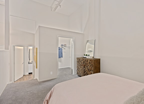 Bedroom with bed and lamps at The Lofts at Shillito Place, Cincinnati, OH
