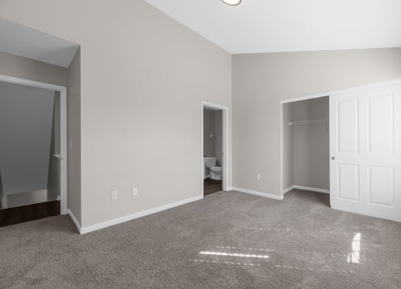 an empty living room with a carpeted floor and a closet at Traditions at Slate Ridge, Reynoldsburg, OH 43068 