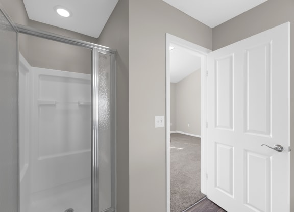 a bathroom with a glass shower and a door to a closet at Traditions at Slate Ridge, Reynoldsburg 